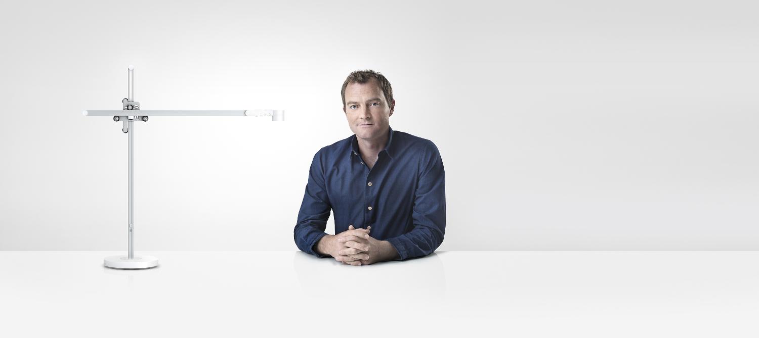 Jake Dyson sitting next to the Dyson Lightcycle™ task light